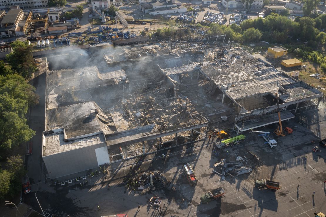 Firefighters work to remove debris at a shopping center burned after a rocket attack in Kremenchuk, Ukraine.