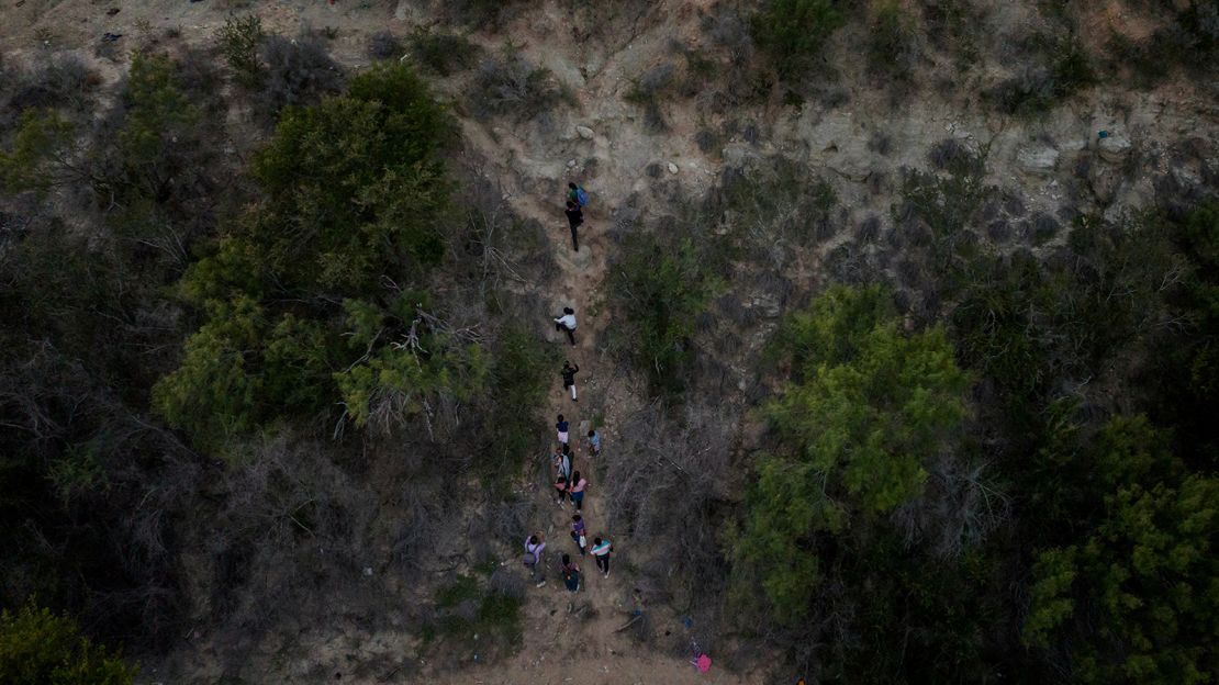 Migrant families climb a steep bank after crossing the Rio Grande into the US on June 16.