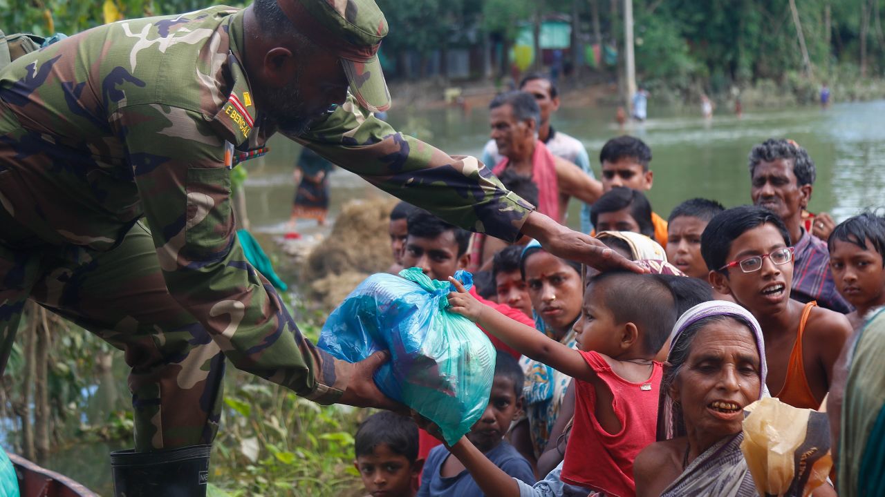 A member of the Bangladesh military distributes food to flood-affected residents in Sylhet on June 25.