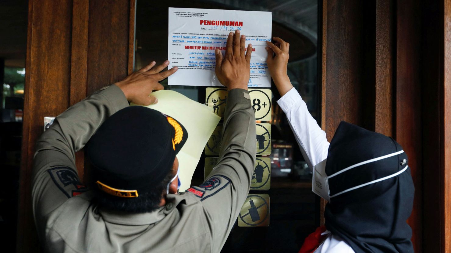 Municipal officers seal the Holywings bar in Jakarta, Indonesia, on June 28 after police charged six employees with blasphemy over a drinks promotion.