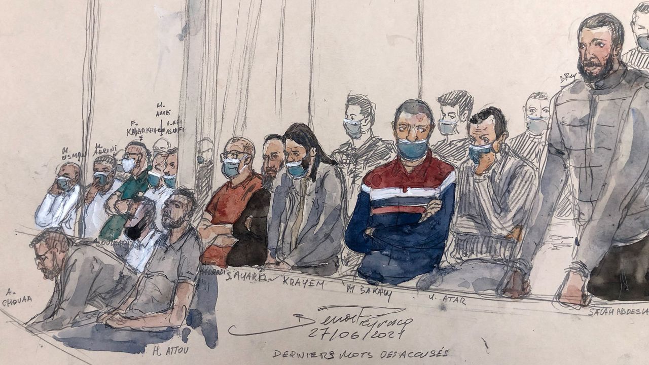 This court sketch shows Salah Abdeslam (right) standing next to 13 other defendants at the Palais de Justice in central Paris on Monday.