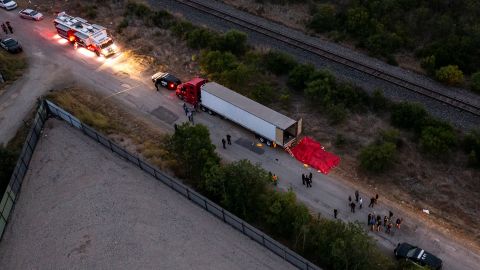 In this aerial view, members of law enforcement investigate a tractor trailer on June 27, 2022 in San Antonio, Texas. More than 50 people were found dead in an abandoned tractor trailer. 