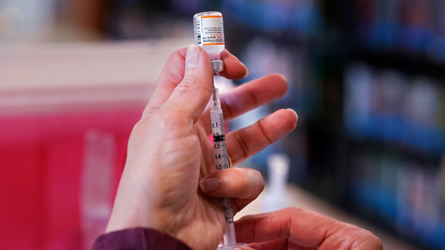 Debbie Breton, a nurse with Northern Light Health, fills a syringe with a Pfizer Covid-19 vaccine dose at a vaccine clinic at Memorial Middle School in South Portland, Maine, on November 19, 2021.