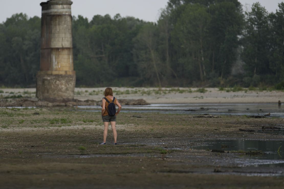 A woman stands on the Po riverbed next to Ponte della Becca (Becca bridge) in Linarolo, near Pavia, Italy, on June 27, 2022.