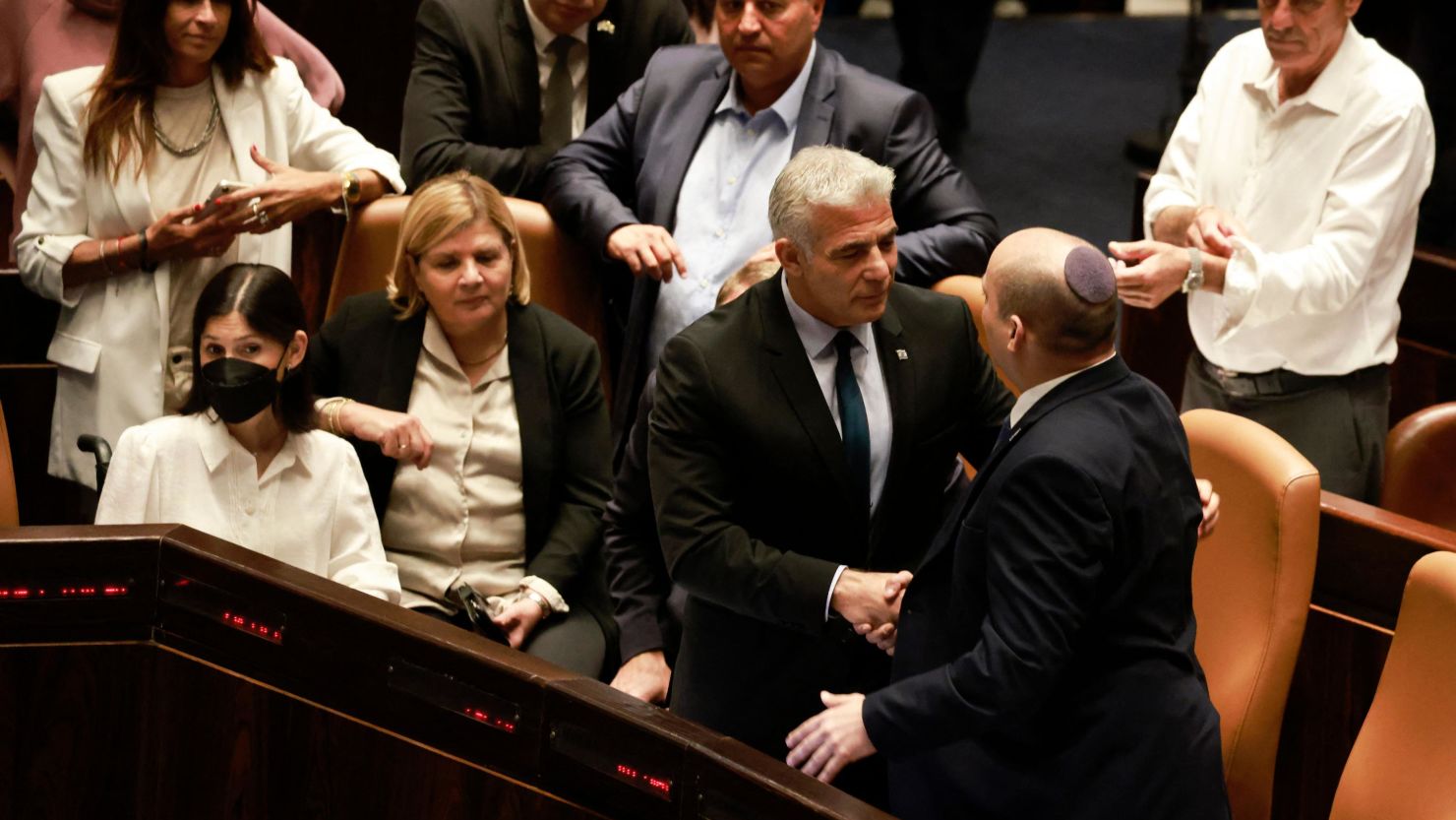 Lapid (center) and Bennett (right) embraced in the Knesset after Thursday's vote.