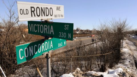 This 2010 photo shows a sign for "Old Rondo Ave.: 1865-1966" standing atop other street signs overlooking Interstate 94, left, and a frontage road in St. Paul, Minn., where homes, stores and other businesses once stood. (AP Photo/Jim Mone)