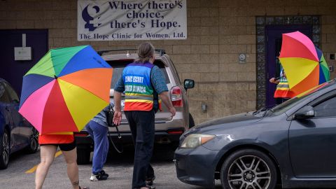 Volunteer clinic escorts shield a patient from anti-abortion demonstrators at the Hope Clinic For Women in Granite City, Illinois, on June 25, 2022.