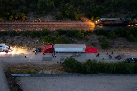 Law enforcement officials investigate a tractor-trailer in San Antonio on Monday, June 27. Inside they found dozens of dead migrants. <a href=