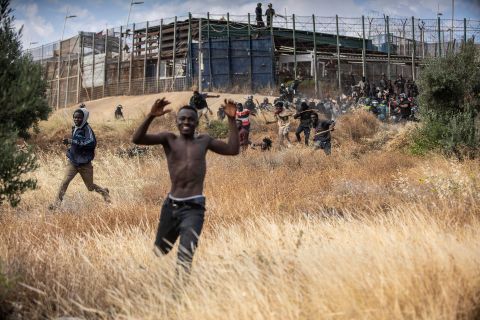 Migrants run on Spanish soil after crossing the fences separating the Spanish enclave of Melilla from Morocco on Friday, June 24. Dozens of migrants stormed the border crossing. It was the first such incursion since Spain and Morocco mended diplomatic relations last month.