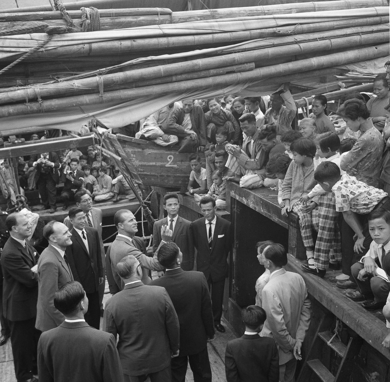 Britain's Prince Philip speaks with locals aboard a fishing vessel at the Aberdeen floating village in Hong Kong in 1959. Hundreds of fishermen crowded the decks of the junks to catch a glimpse of the prince as he made his tour. 