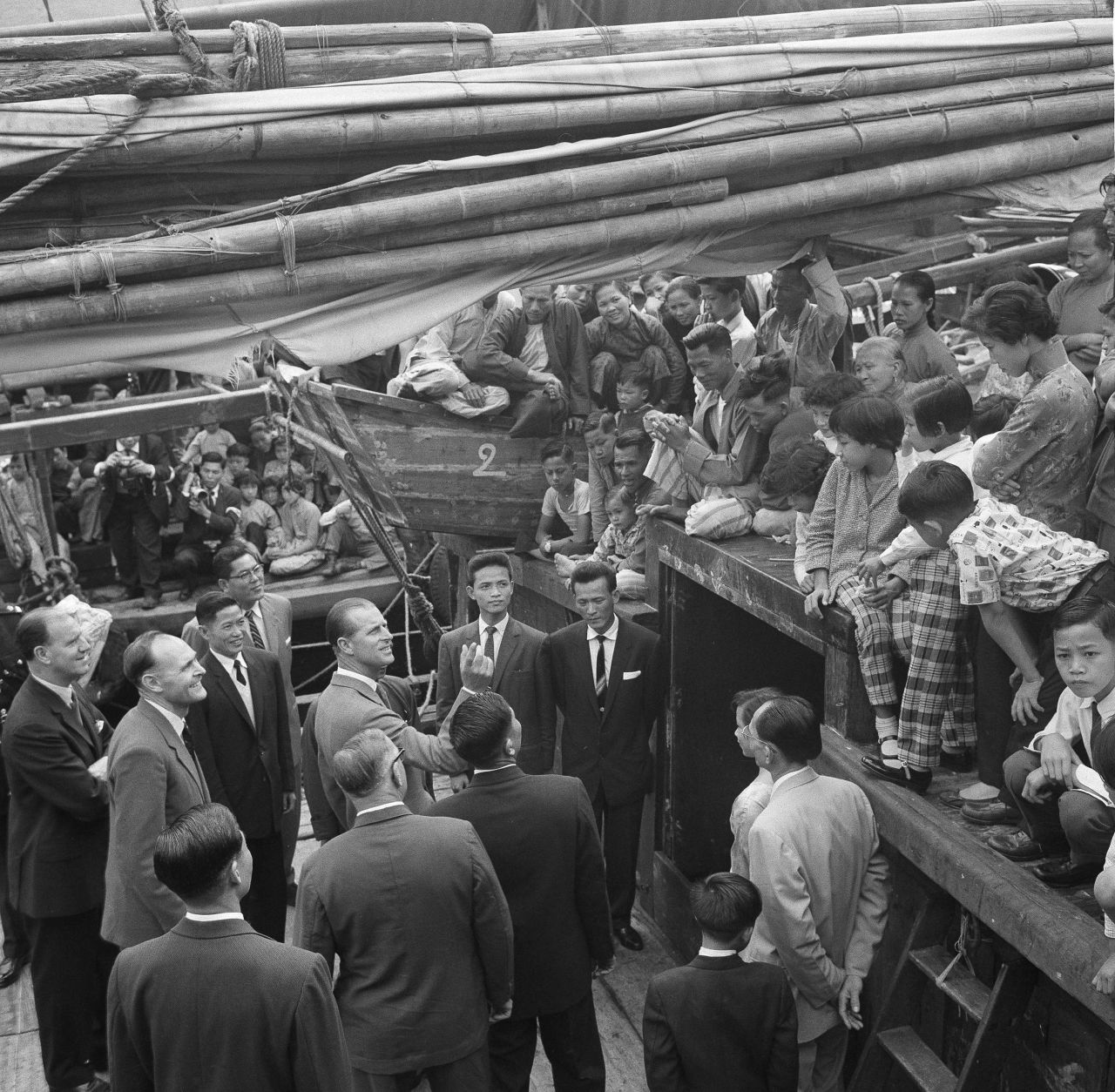 Britain's Prince Philip speaks with locals aboard a fishing vessel at the Aberdeen floating village in Hong Kong in 1959. Hundreds of fishermen crowded the decks of the junks to catch a glimpse of the prince as he made his tour.
