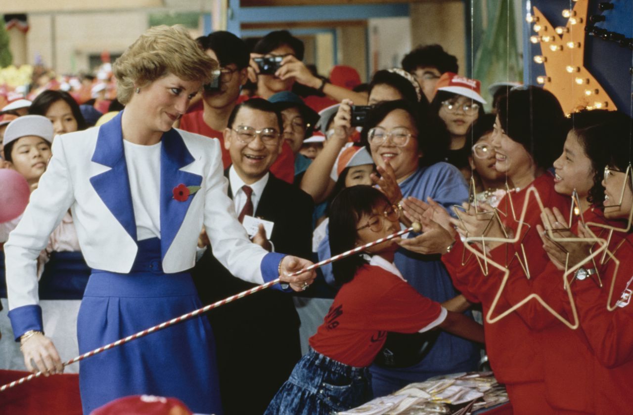Princess Diana holds a thin pole while greeting well-wishers during a visit to the Chak On public housing estate in Hong Kong in 1989.