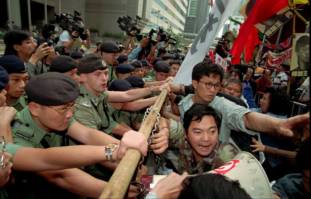 Pro-democracy activists scuffle with police officers outside the Hong Kong Convention Center as they protest the visit of Chinese Foreign Minister Qian Qichen on November 15, 1996. The protesters claimed that Qian was the harbinger of "illegal" changes to Hong Kong's political system.