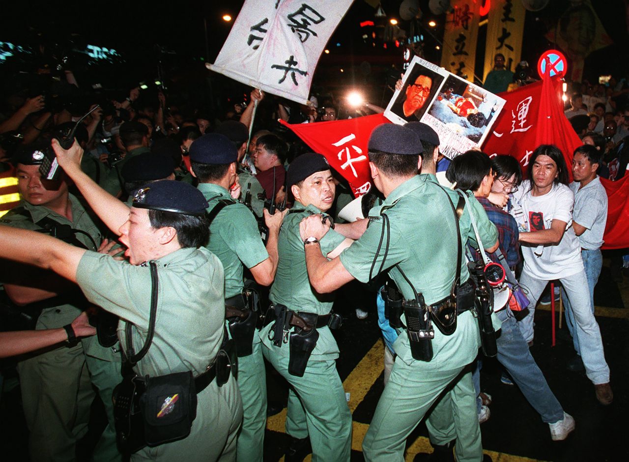 Demonstrators push through police lines on June 30, 1997, as they attempt to march to the venue where the handover ceremony was taking place at midnight. 