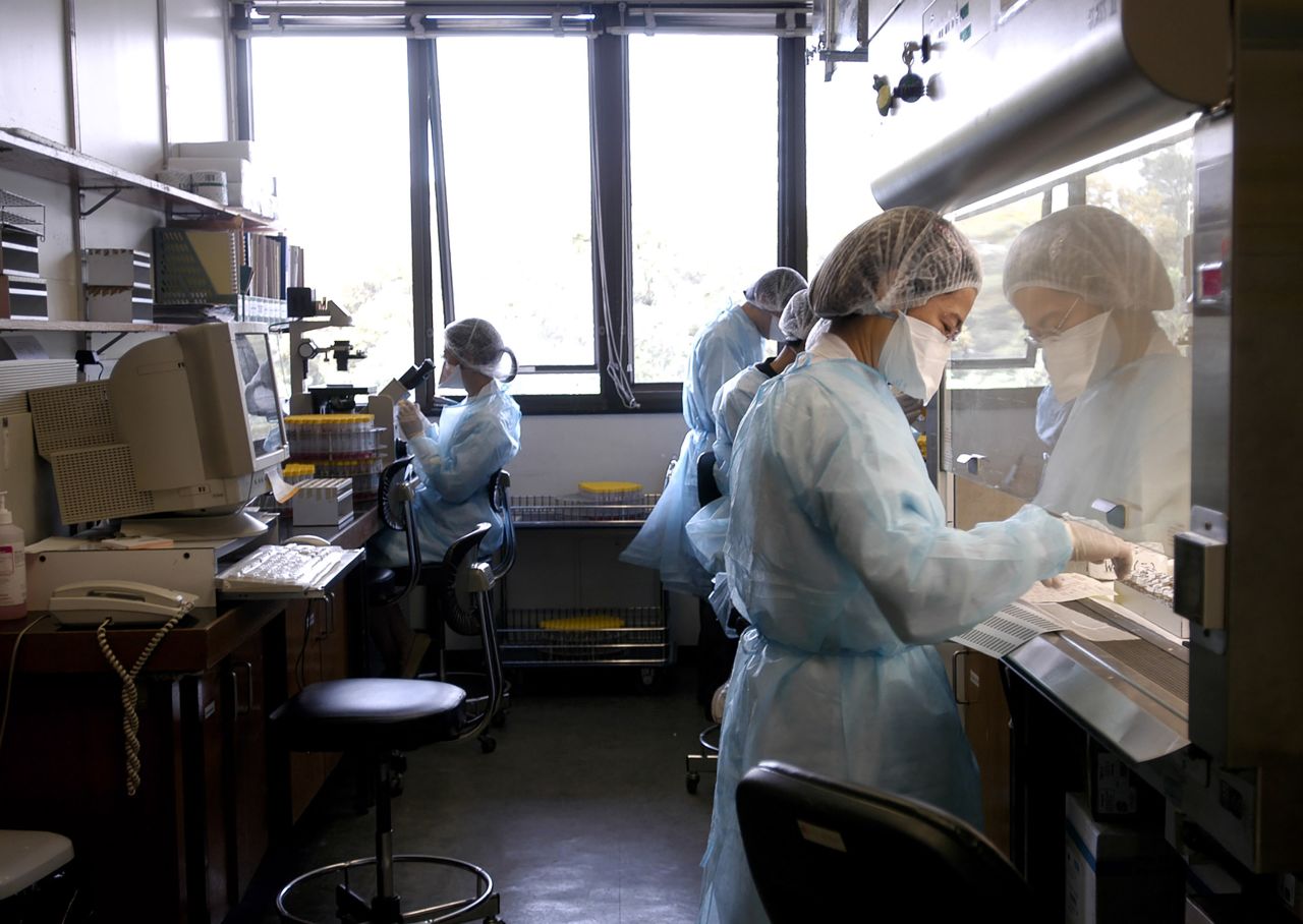 Medical workers wearing masks and protective gowns work in a laboratory for the SARS virus at Hong Kong's Prince of Wales Hospital in 2003.