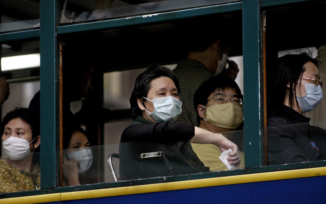 Hong Kong residents wear face masks on a bus during the SARS epidemic in 2003.