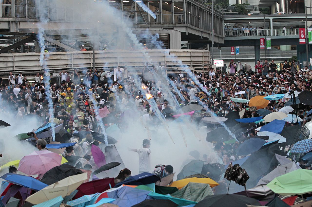 Riot police fire tear gas as thousands of protesters surround Hong Kong's government headquarters on September 28, 2014, at the beginning of the Umbrella Movement. The protests were sparked by new election rules, issued by the Chinese government, that candidates must be vetted in advance by a pro-Beijing committee.
