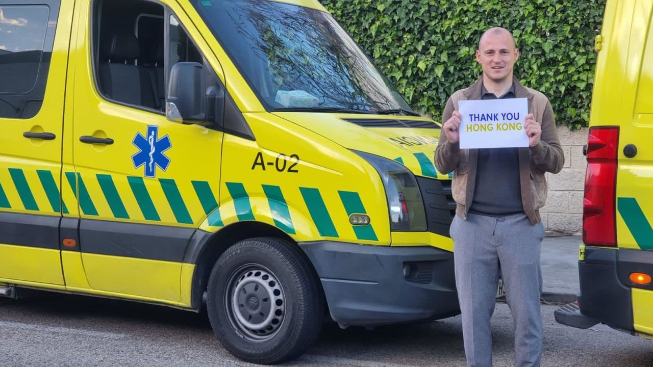 Ukrainian footballer Roman Zozulya holds a 'Thank You Hong Kong' sign in front of an ambulance to be sent from Spain to Ukraine.