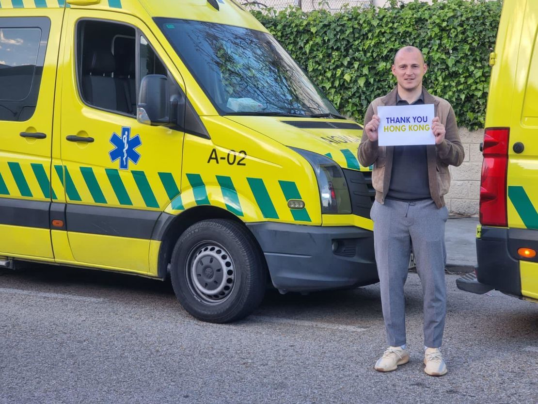 Ukrainian footballer Roman Zozulya holds a 'Thank You Hong Kong' sign in front of an ambulance to be sent from Spain to Ukraine.