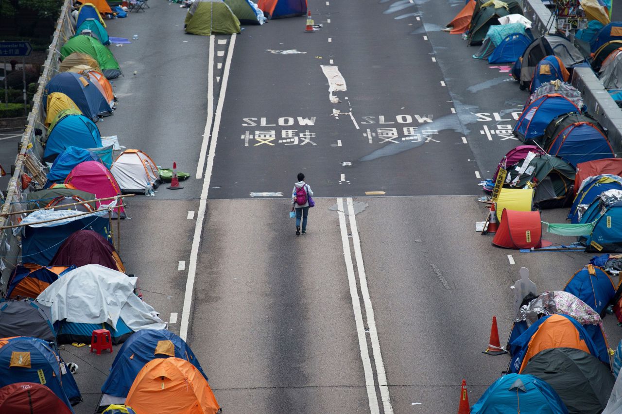A person walks through the Umbrella Movement's main protest site in the Admiralty district of Hong Kong on December 3, 2014. The original founders of the movement tearfully announced on December 2 they would "surrender" by turning themselves in to police, and they urged protesters on the streets to retreat.