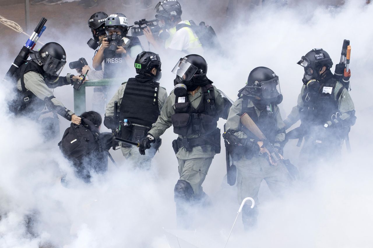 Police in riot gear move through a cloud of smoke as they detain a protester at the Hong Kong Polytechnic University in 2019.