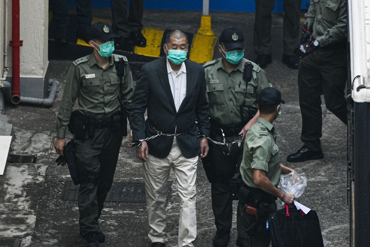 Hong Kong media tycoon Jimmy Lai, founder and owner of the pro-democracy newspaper Apple Daily, is handcuffed and escorted by guards leaving the Lai Chi Kok Reception Center in Hong Kong on December 12, 2020. Lai was accused of collusion with foreign forces to endanger national security, which carries a maximum penalty of life imprisonment under the city's sweeping national security law imposed by Beijing.