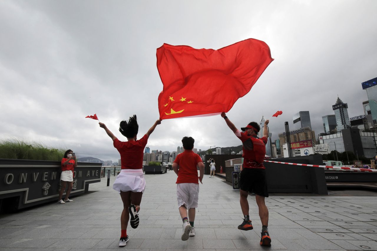 People run with a Chinese flag in Hong Kong on the <a href="https://www.cnn.com/asia/live-news/hong-kong-china-anniversary-07-01-22-intl-hnk/index.html" target="_blank">25th anniversary</a> of Hong Kong's handover from British to Chinese rule on Friday, July 1.