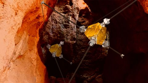 An artist's concept shows ReachBot exploring a Martian cave.