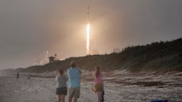 Spectators watch from Canaveral National Seashore as a SpaceX Falcon 9 rocket carrying 60 Starlink satellites launches from pad 39A at the Kennedy Space Center on October 6, 2020 in Cape Canaveral, Florida. 