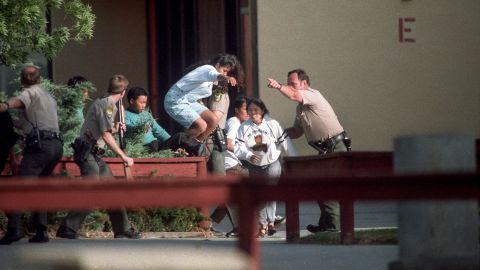 Officers evacuate students at Lindhurst High School in Olivehurst, California, after former student Eric Houston seized hostages on the campus on May 1, 1992. 


