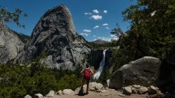 A tourist takes in Liberty Cap and Nevada Falls at Yosemite National Park in California.