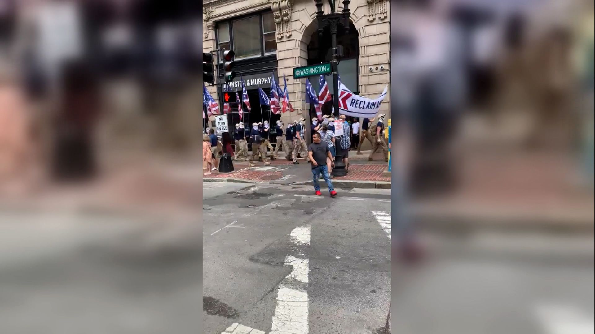 Group wielding White nationalist flags march along Boston's
