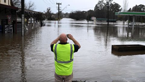 A local snaps a photo of a flood-flooded road in Sydney's South West Camden, Sunday, July 3, 2022.