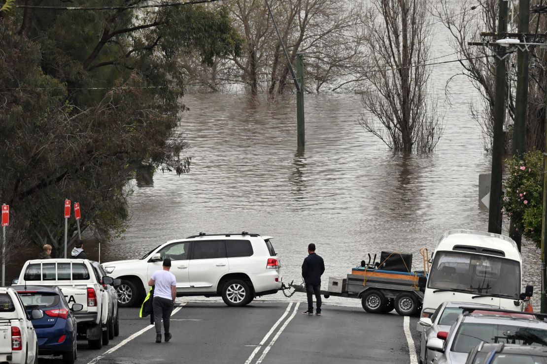 Locals save furniture from a house threatened by floodwaters in Camden, South Western Sydney, July 3, 2022.
