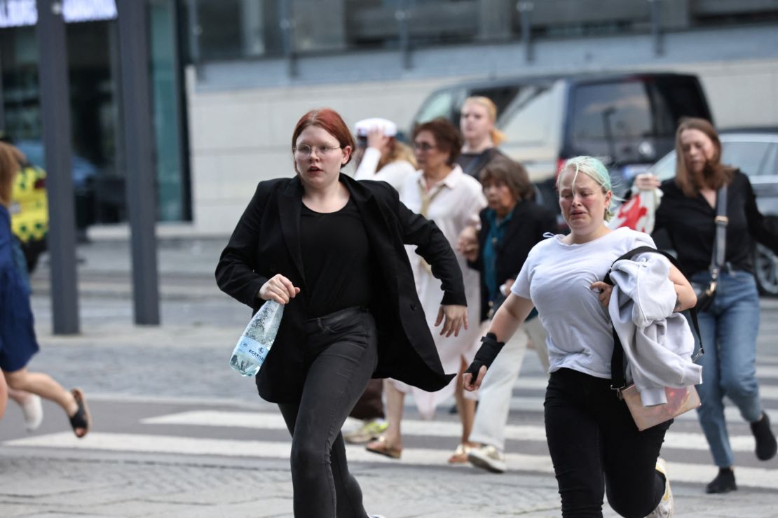 People run out of the Field's shopping center in Copenhagen, Denmark on July 3, 2022. 