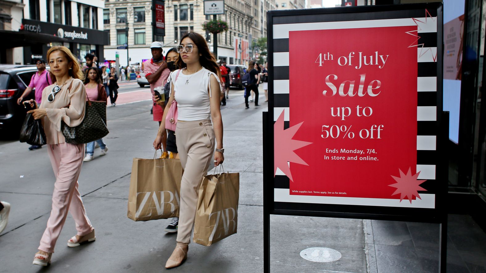 People walk in front of a Sephora store in New York on Saturday. Many retailers across the country have had Fourth of July weekend sales.