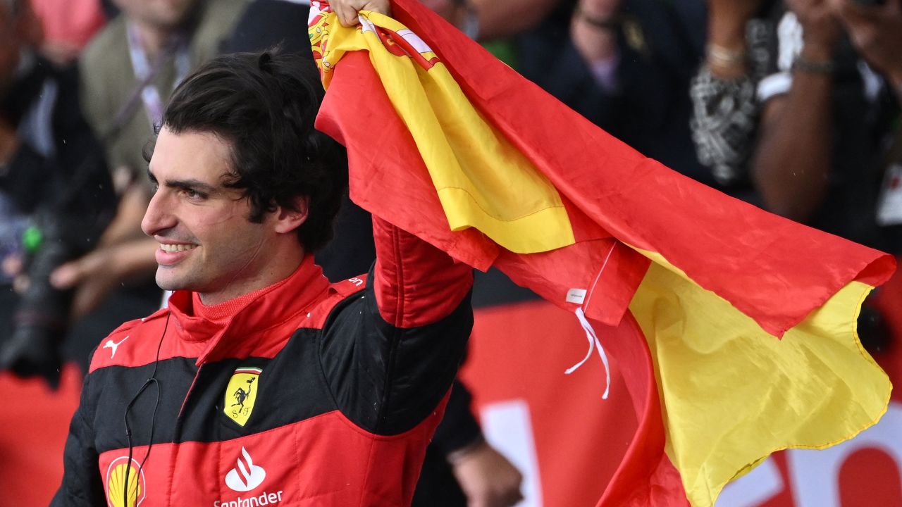 Carlos Sainz waves a Spanish flag as he celebrates his win. 