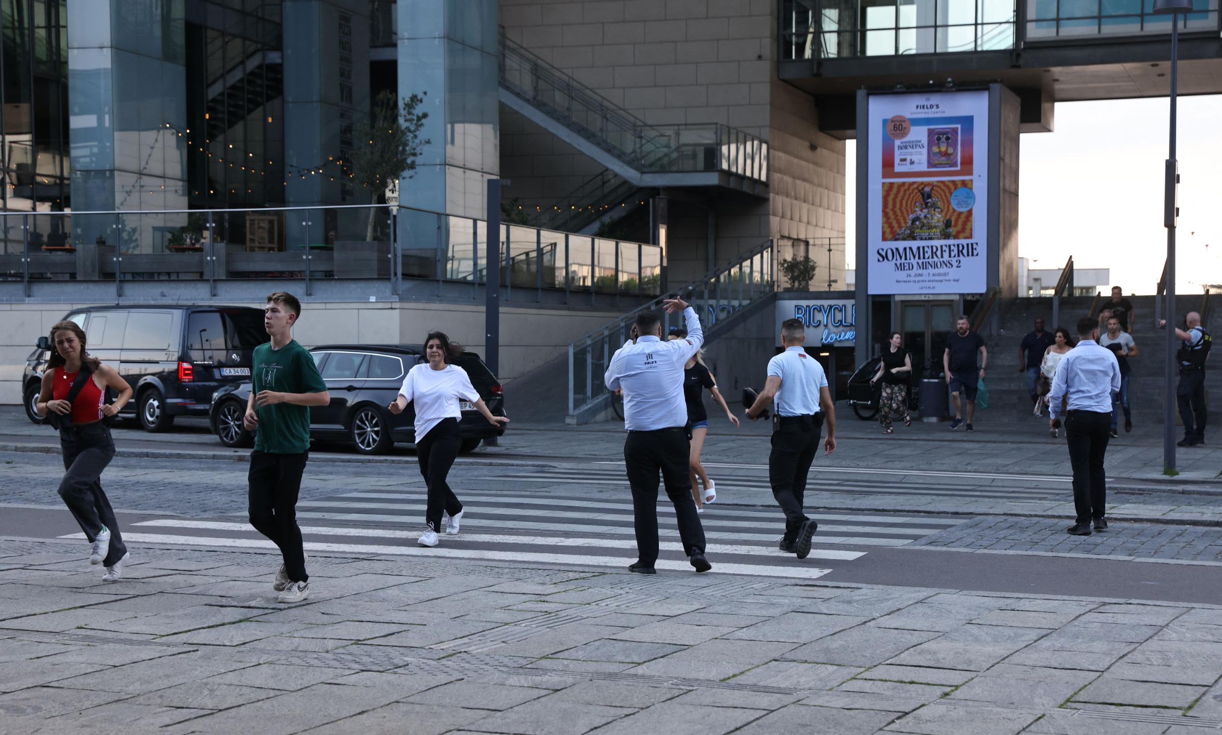 Security personnel guide people to safety as they evacuate the Field's shopping center in Copenhagen, Denmark, following a shooting on July 3.