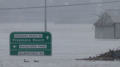 Road signs are seen submerged under floodwater along the Hawkesbury River in the suburb of Windsor, on July 4, 2022.