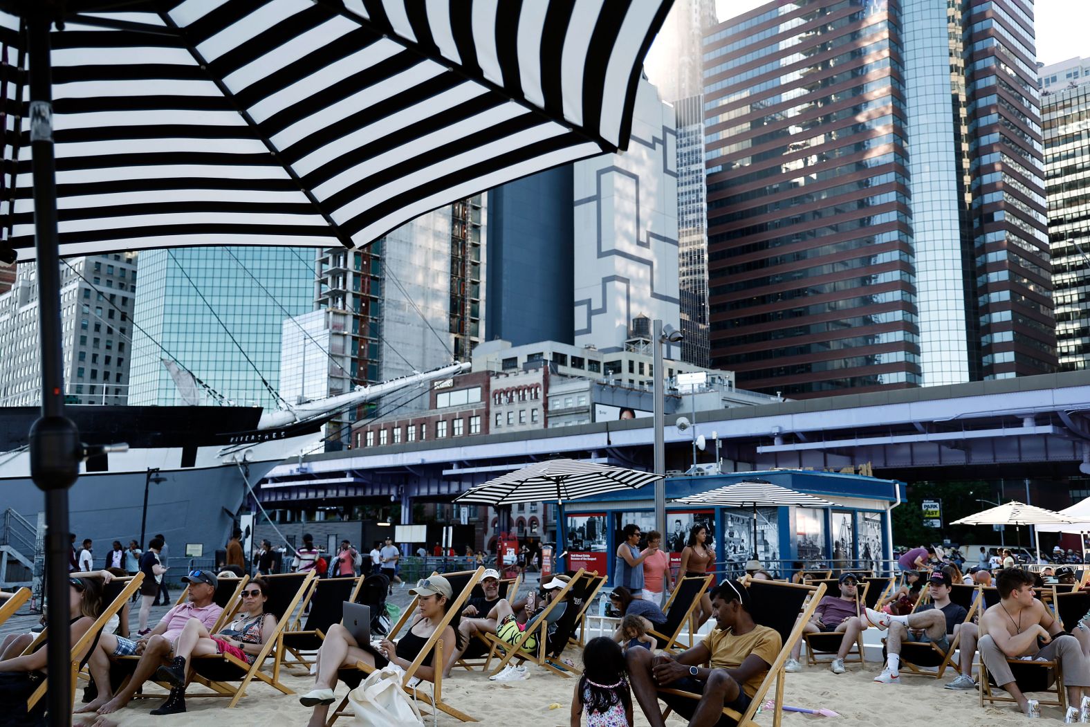 People relax on a makeshift beach at the South Street Seaport in New York on Sunday.