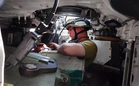 A Ukrainian soldier with the 14th Mechanized Brigade of Prince Roman the Great works in his tank as the unit awaits their next mission on July 1.