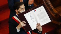 Chilean President Gabriel Boric shows the final draft of the constitutional proposal after signing it during its presentation at the National Congress in Santiago, on July 4, 2022. The Constitutional Convention submitted the final draft Constitution to Chilean President Gabriel Boric.