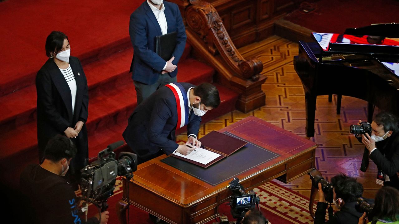President Boric signing the proposal.