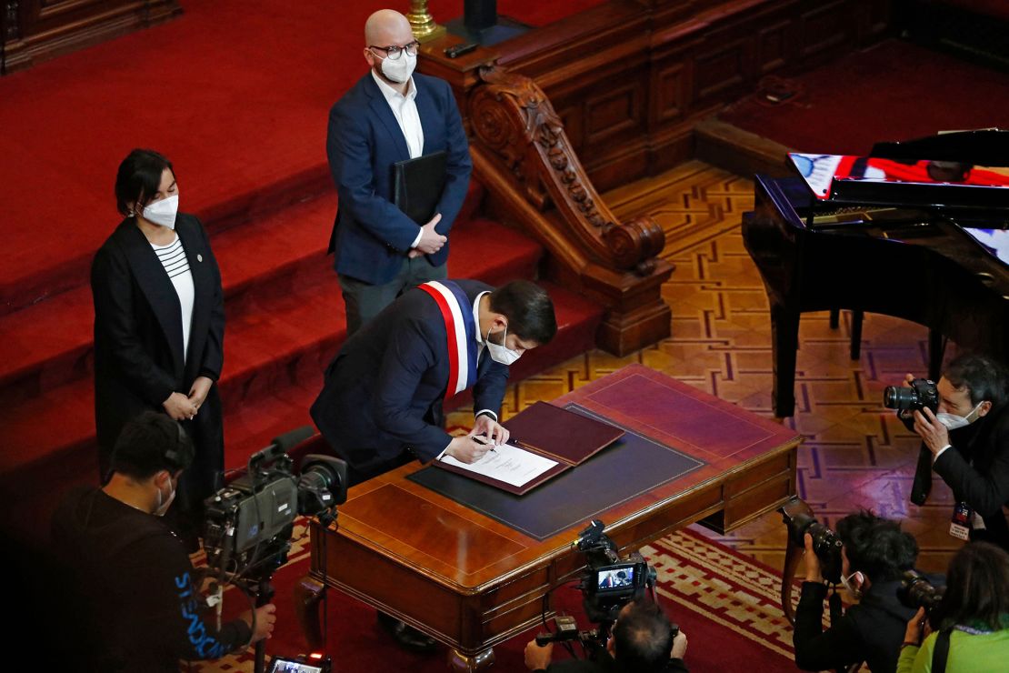 President Boric signing the proposal.