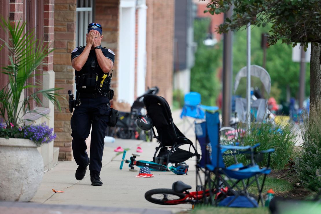 A Lake County police officer walks down Central Ave in Highland Park on Monday.