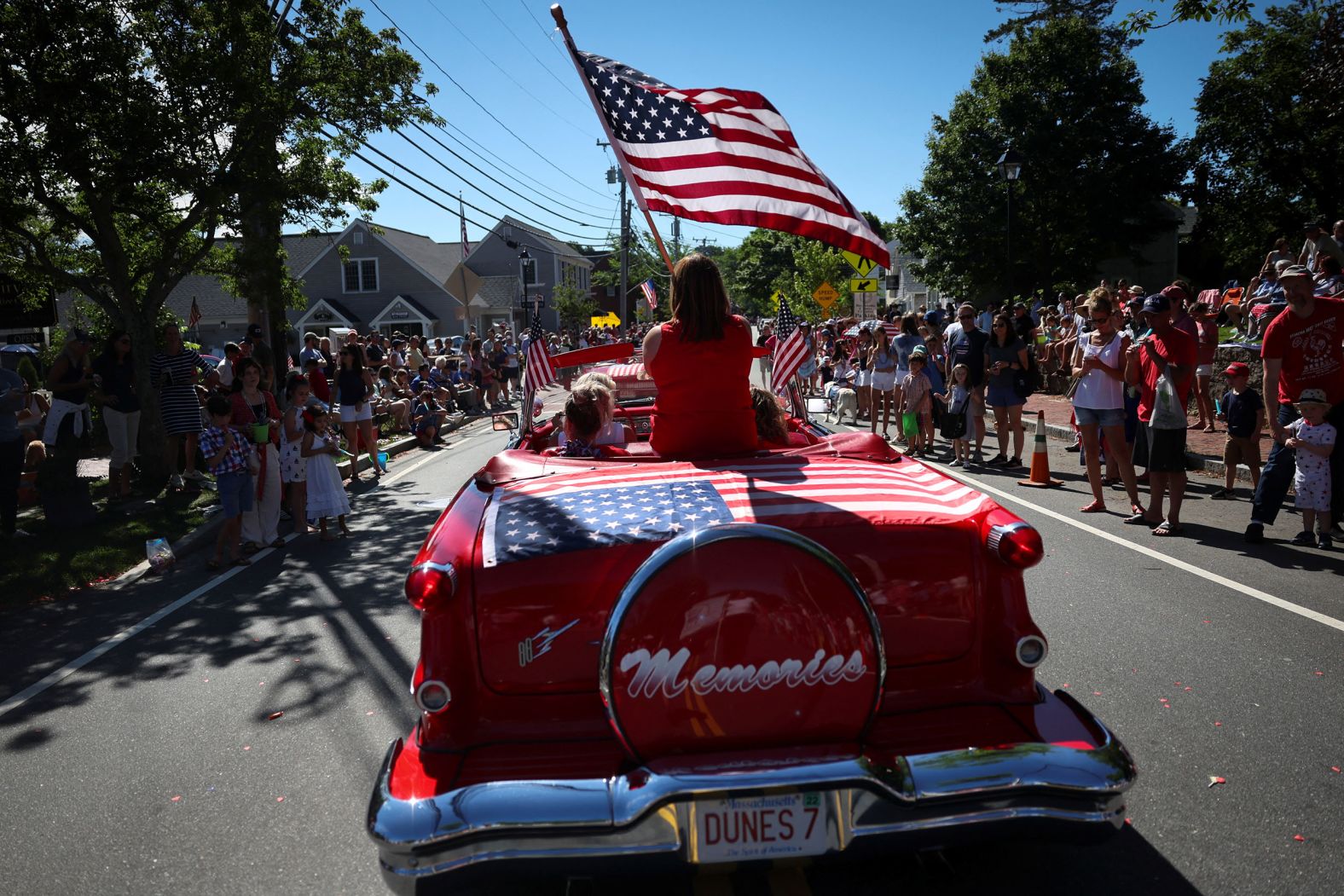 A woman waves the American flag on an antique car during a Fourth of July parade in Barnstable, Massachusetts, on Monday.