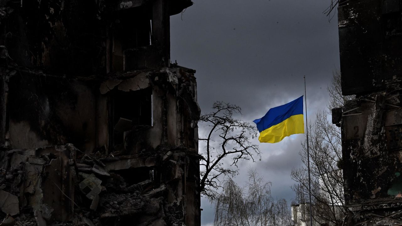 TOPSHOT - The Ukrainian flag flutters between buildings destroyed in bombardment, in the Ukrainian town of Borodianka, in the Kyiv region on April 17, 2022. - Russia invaded Ukraine on February 24, 2022. (Photo by Sergei SUPINSKY / AFP) (Photo by SERGEI SUPINSKY/AFP via Getty Images)