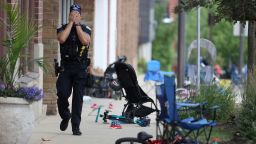 A Lake Forest police officer walks down Central Avenue in Highland Park, Ill., on Monday, July 4, 2022, after a shooter fired on the northern suburb's Fourth of July parade. 