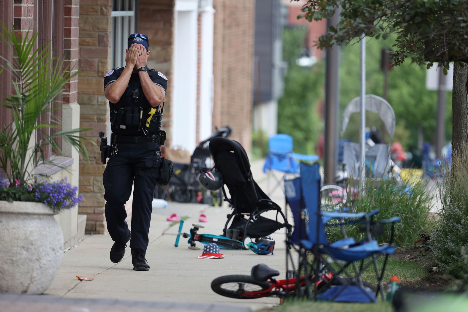 A Lake Forest police officer walks down Central Avenue in Highland Park on July 4. 