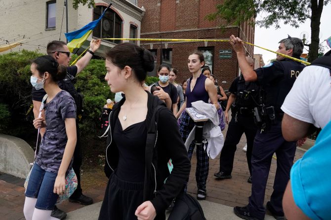 Students are escorted by police officers to safety after a mass shooting at the Highland Park Fourth of July parade on Monday.  